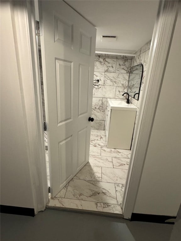 bathroom with vanity and marble finish floor