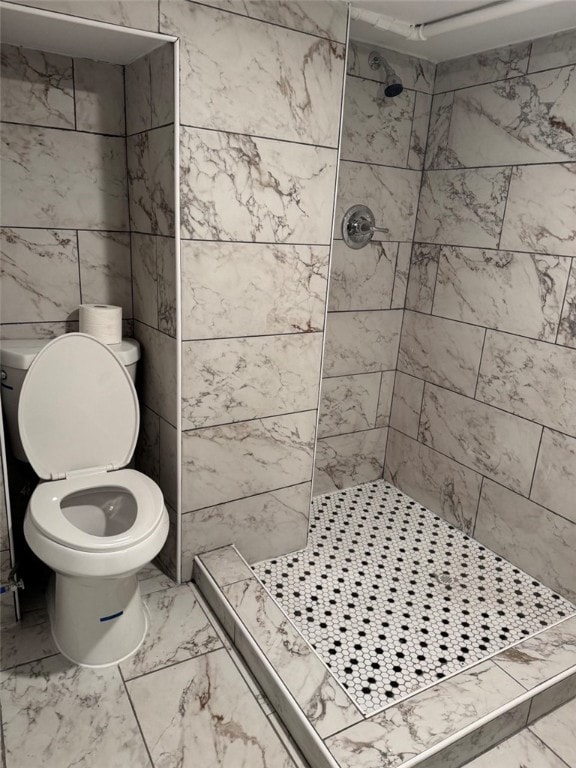 bathroom featuring a stall shower, toilet, and marble finish floor