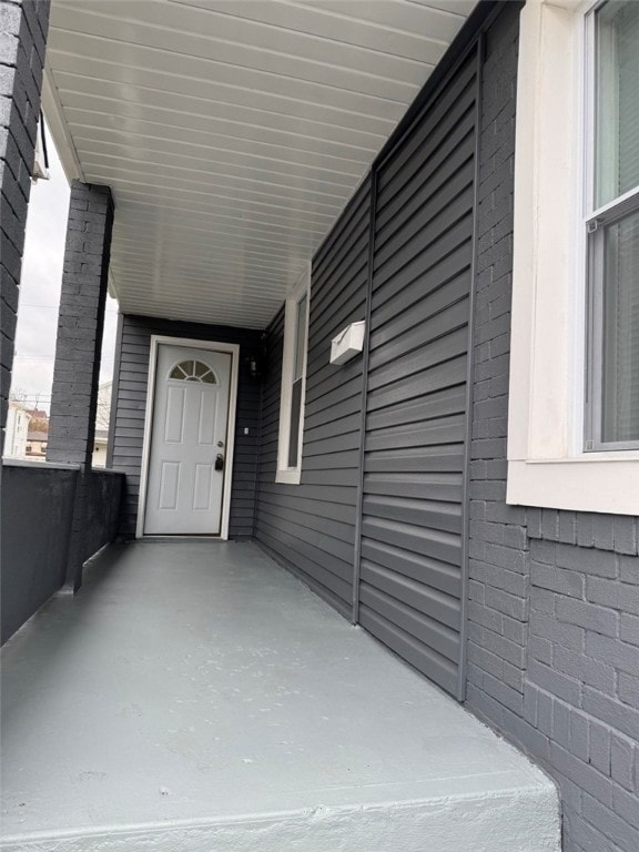 doorway to property featuring an attached carport