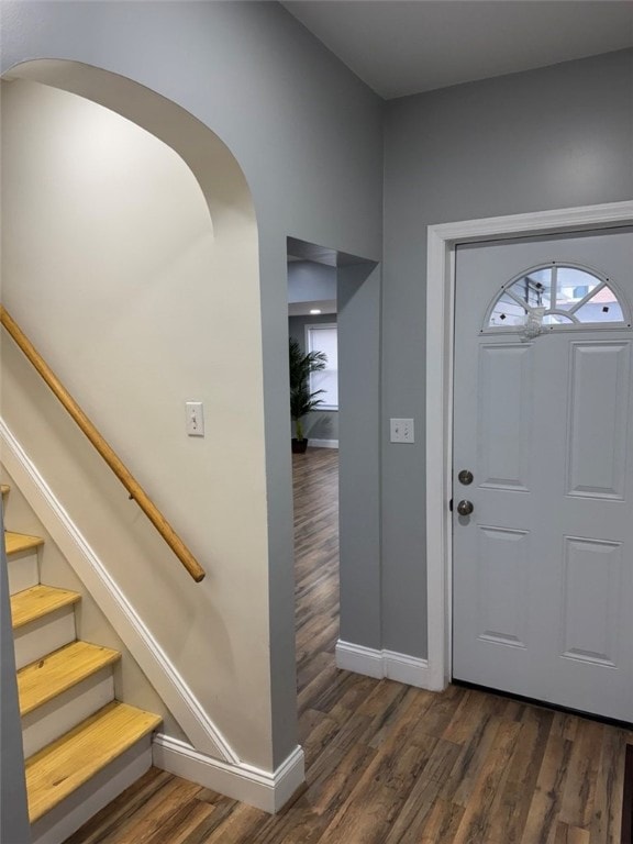 foyer with baseboards, stairs, and dark wood-type flooring