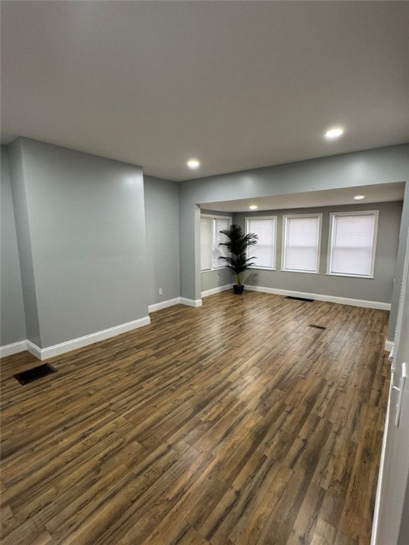 unfurnished living room featuring recessed lighting, dark wood finished floors, and baseboards