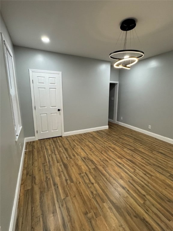 interior space featuring recessed lighting, an inviting chandelier, wood finished floors, and baseboards
