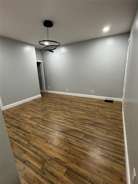 unfurnished room featuring baseboards, visible vents, dark wood-style flooring, and recessed lighting