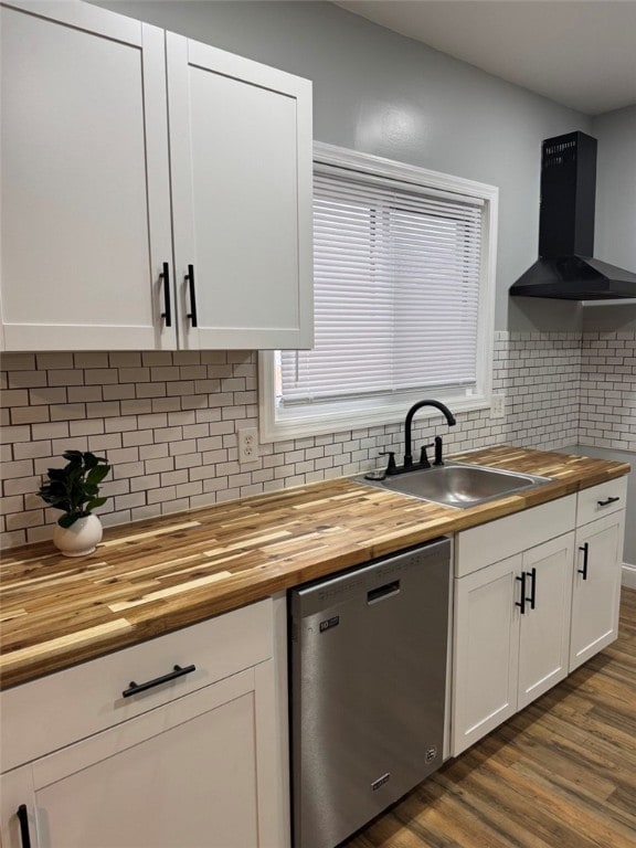 kitchen featuring exhaust hood, a sink, wood counters, backsplash, and stainless steel dishwasher