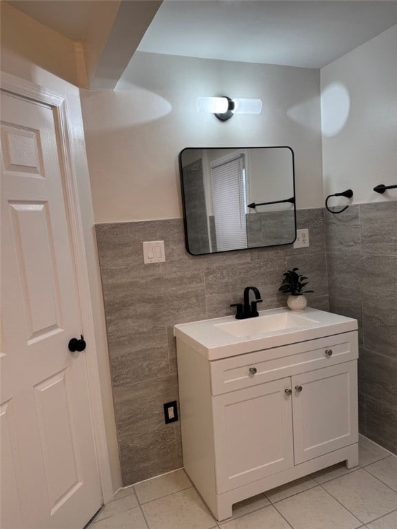bathroom with vanity, tile walls, wainscoting, and tile patterned floors