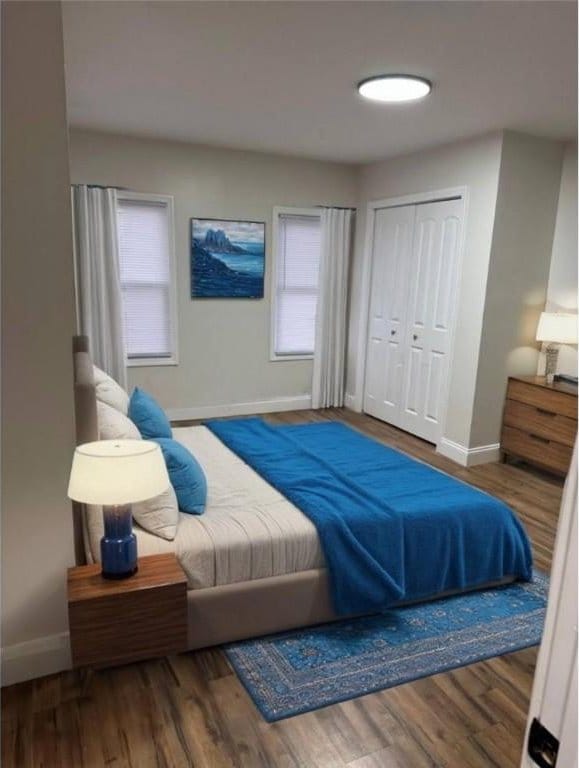 bedroom with baseboards, wood finished floors, and a closet