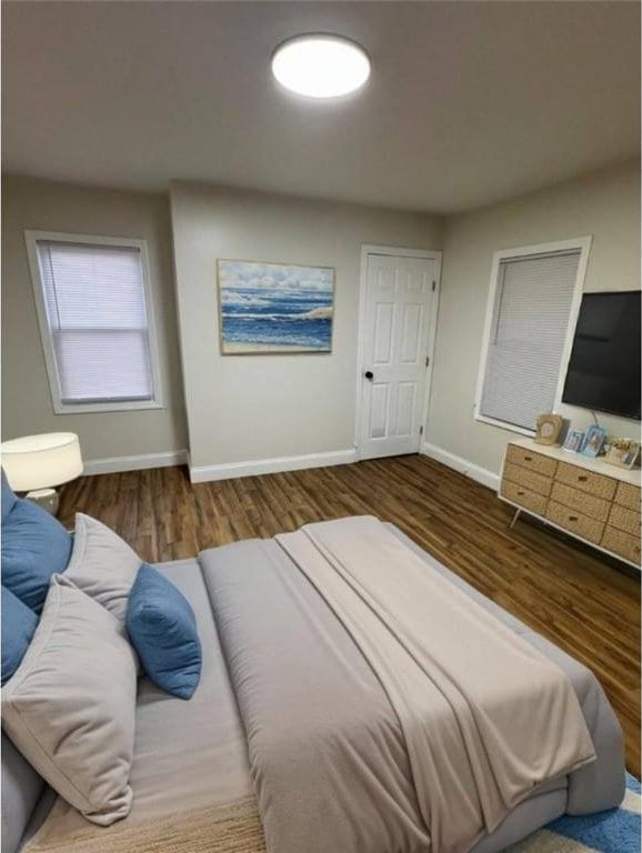 bedroom with wood finished floors and baseboards