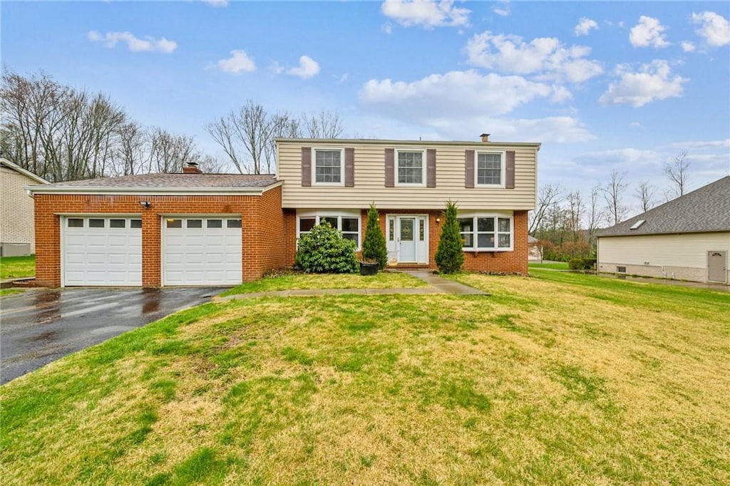8 Spring Run Rd, Unity Twp, PA 15601 - colonial inspired home featuring a chimney, aphalt driveway, brick siding, a front yard, and a garage