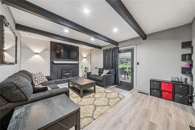 living area featuring baseboards, a brick fireplace, beamed ceiling, recessed lighting, and wood finished floors
