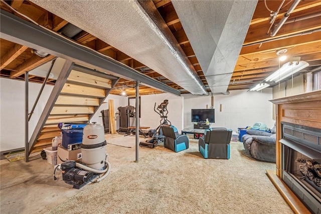 basement featuring concrete block wall and stairs