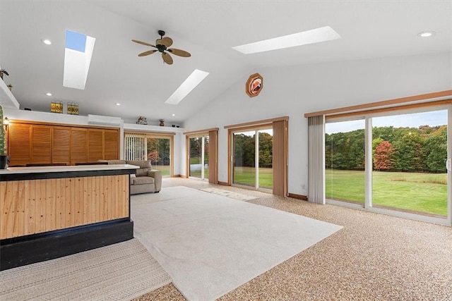 interior space featuring baseboards, recessed lighting, a skylight, high vaulted ceiling, and carpet