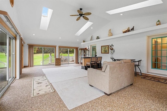 carpeted living area featuring a skylight, high vaulted ceiling, and recessed lighting