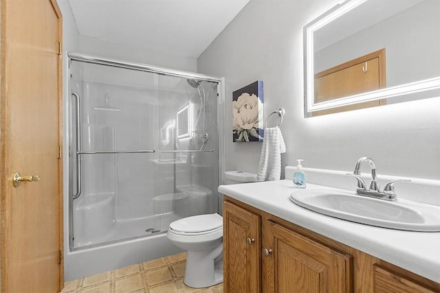 full bathroom featuring tile patterned floors, vanity, a stall shower, and toilet