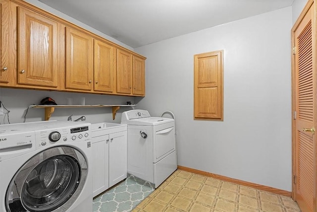 clothes washing area featuring baseboards, washing machine and clothes dryer, cabinet space, light floors, and a sink
