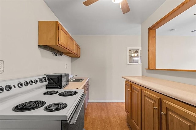 kitchen with light wood finished floors, light countertops, white electric range oven, black microwave, and ceiling fan