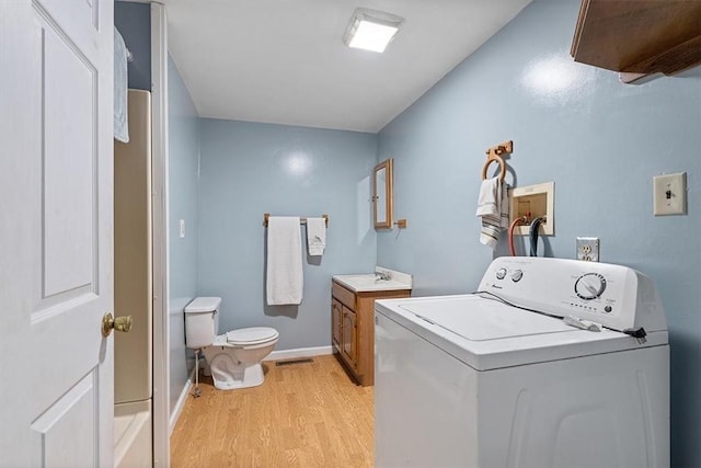 laundry room with washer / clothes dryer, baseboards, light wood-type flooring, laundry area, and a sink