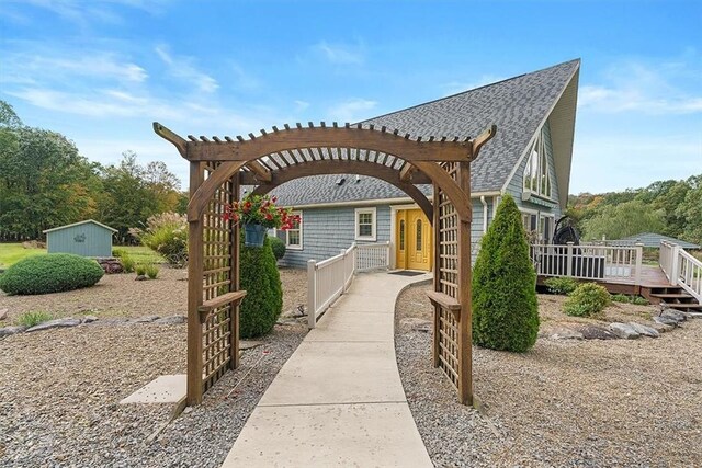 exterior space with a wooden deck, fence private yard, a shingled roof, and a pergola
