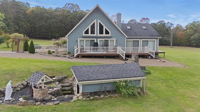 rear view of house featuring a deck, a chimney, and a lawn