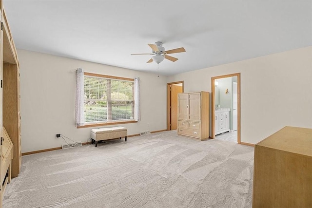 unfurnished bedroom featuring visible vents, baseboards, ensuite bathroom, ceiling fan, and light carpet