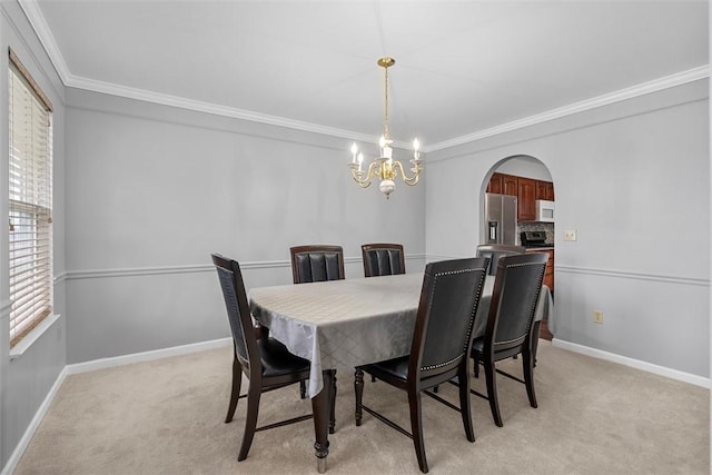 dining space featuring arched walkways, an inviting chandelier, baseboards, and ornamental molding