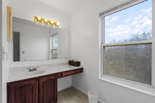 bathroom with a wealth of natural light, vanity, and baseboards