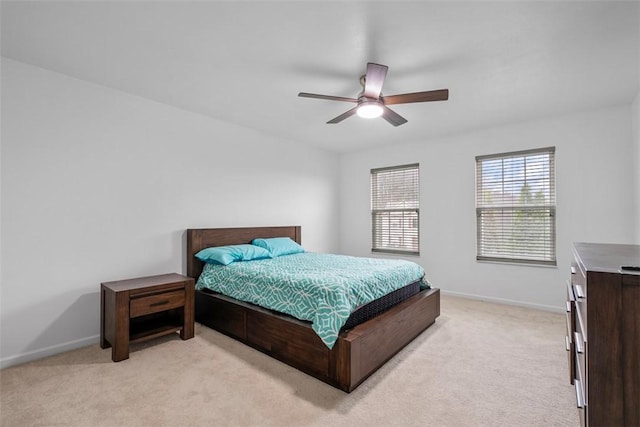 bedroom featuring light carpet, baseboards, and ceiling fan