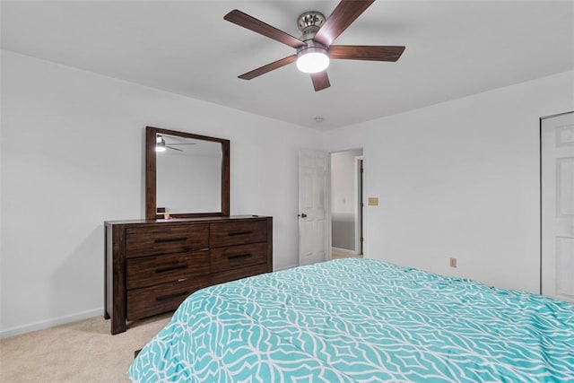 bedroom featuring light colored carpet, baseboards, and a ceiling fan