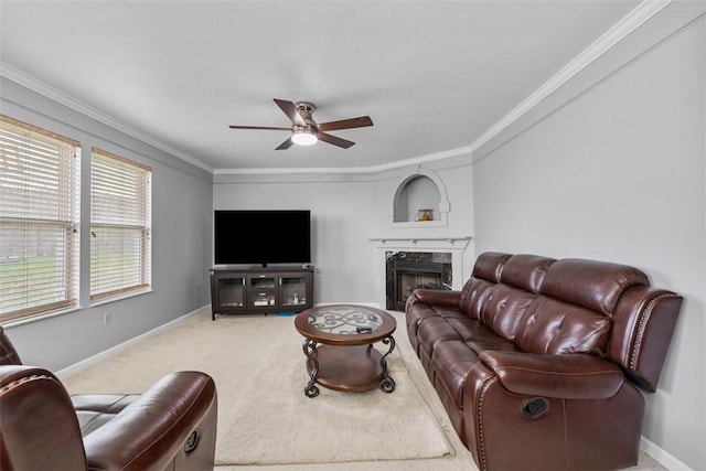 living room with ceiling fan, a high end fireplace, ornamental molding, and baseboards