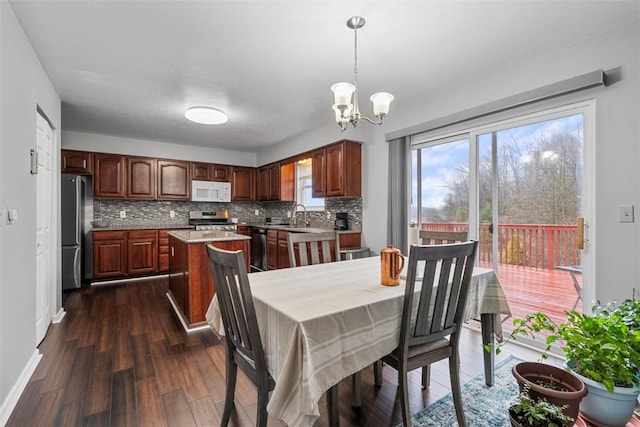 dining space featuring baseboards, an inviting chandelier, and dark wood-style floors