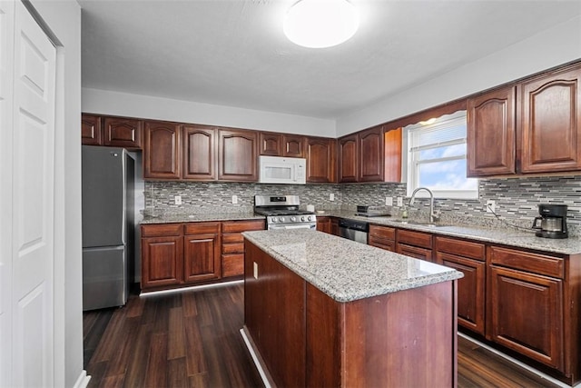 kitchen with decorative backsplash, appliances with stainless steel finishes, dark wood-style flooring, and a sink