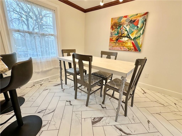 dining area featuring crown molding and baseboards