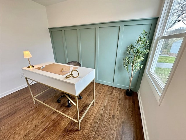 home office with a decorative wall, baseboards, and wood finished floors