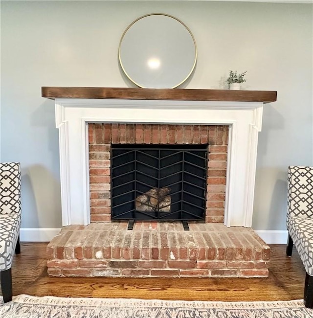 details featuring a fireplace, baseboards, and wood finished floors
