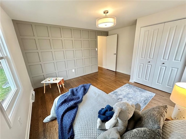 bedroom with a closet, baseboards, and wood finished floors