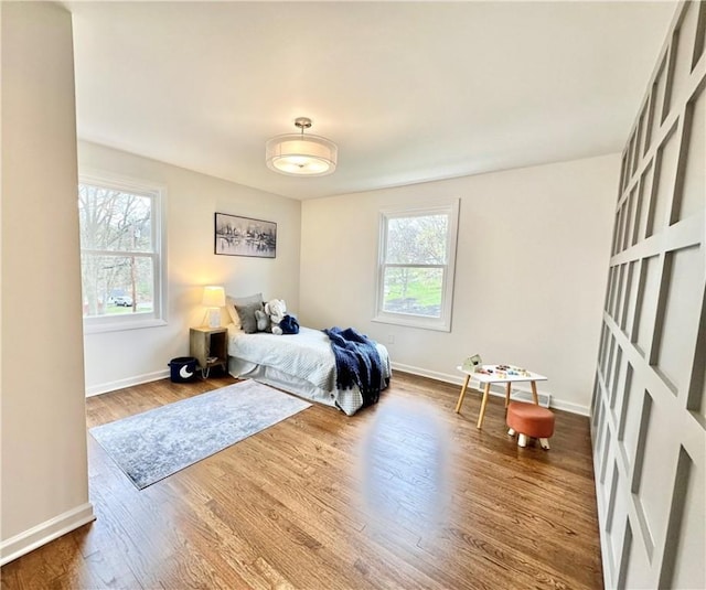 bedroom with baseboards and wood finished floors