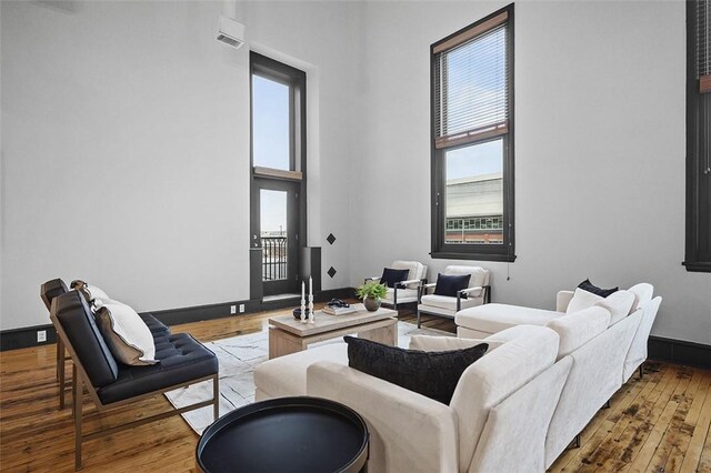 3080 Smallman St, Downtown Pgh, PA 15201 - living room featuring a towering ceiling, wood-type flooring, and baseboards