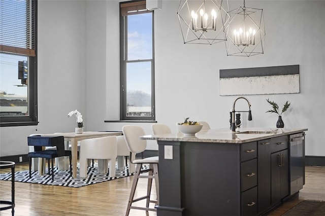 3080 Smallman St, Downtown Pgh, PA 15201 - kitchen featuring a sink, wood finished floors, stainless steel dishwasher, a chandelier, and a center island with sink