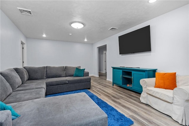 living area with light wood-type flooring, baseboards, visible vents, and recessed lighting
