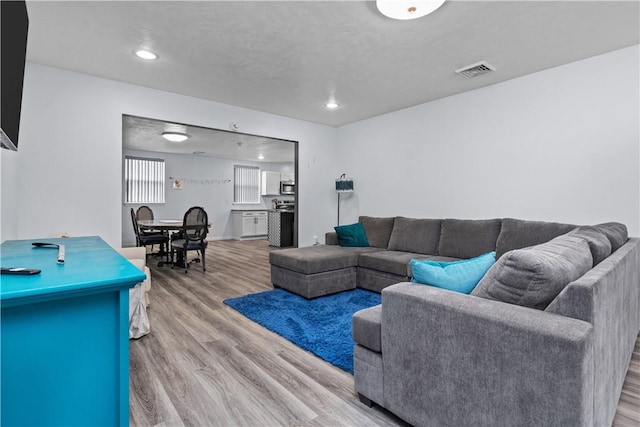 living room featuring recessed lighting, visible vents, and wood finished floors