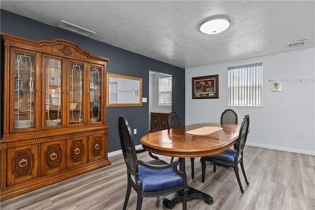 dining area featuring a textured ceiling, visible vents, and a wealth of natural light
