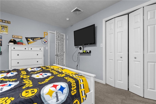 carpeted bedroom featuring a closet, baseboards, and visible vents