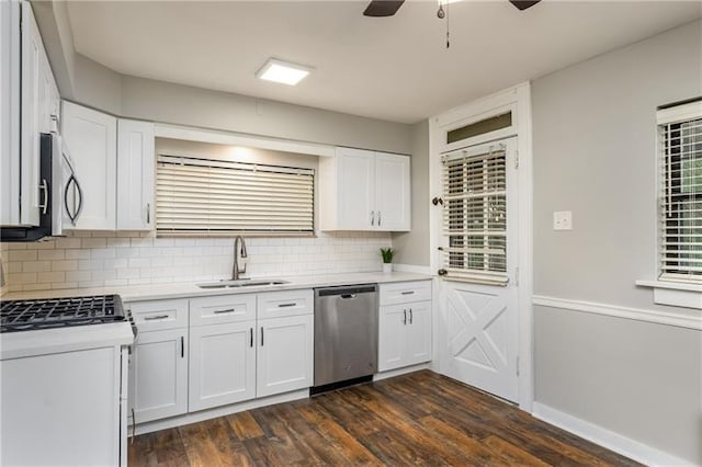 kitchen featuring dark wood-type flooring, appliances with stainless steel finishes, light countertops, a sink, and backsplash