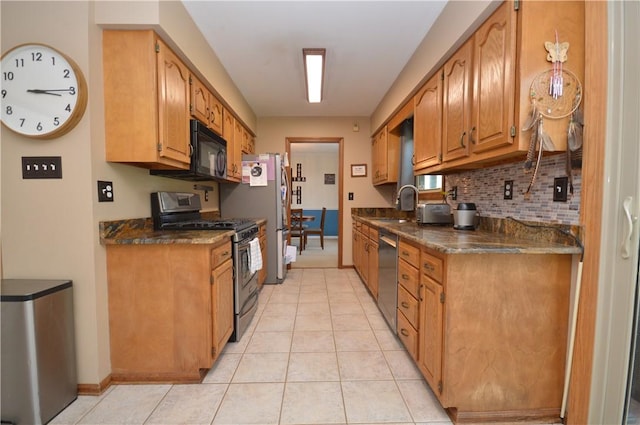 kitchen with light tile patterned floors, brown cabinets, decorative backsplash, stainless steel appliances, and a sink