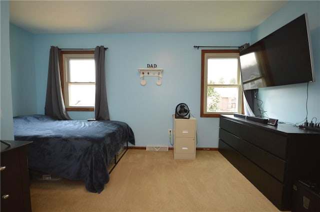 bedroom with visible vents, baseboards, and light carpet