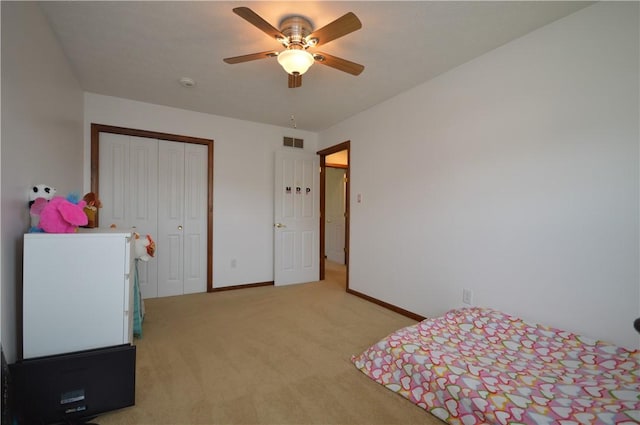bedroom featuring visible vents, baseboards, a closet, a ceiling fan, and light carpet