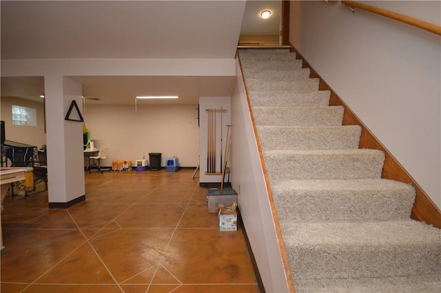 staircase featuring baseboards and tile patterned flooring