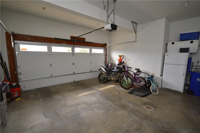garage featuring freestanding refrigerator and a garage door opener