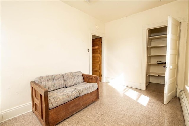 living area with baseboard heating and baseboards