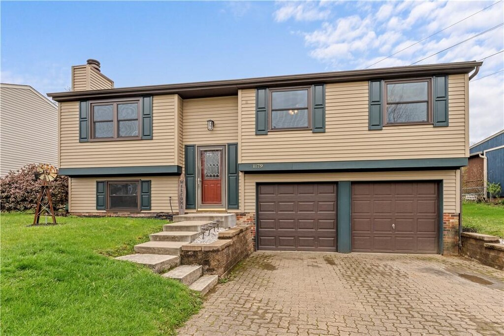 1179 Mike Reed Dr, South Park, PA 15129 - bi-level home featuring a front yard, an attached garage, decorative driveway, and a chimney