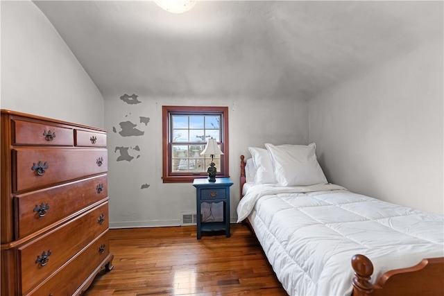 bedroom with wood-type flooring, baseboards, and lofted ceiling